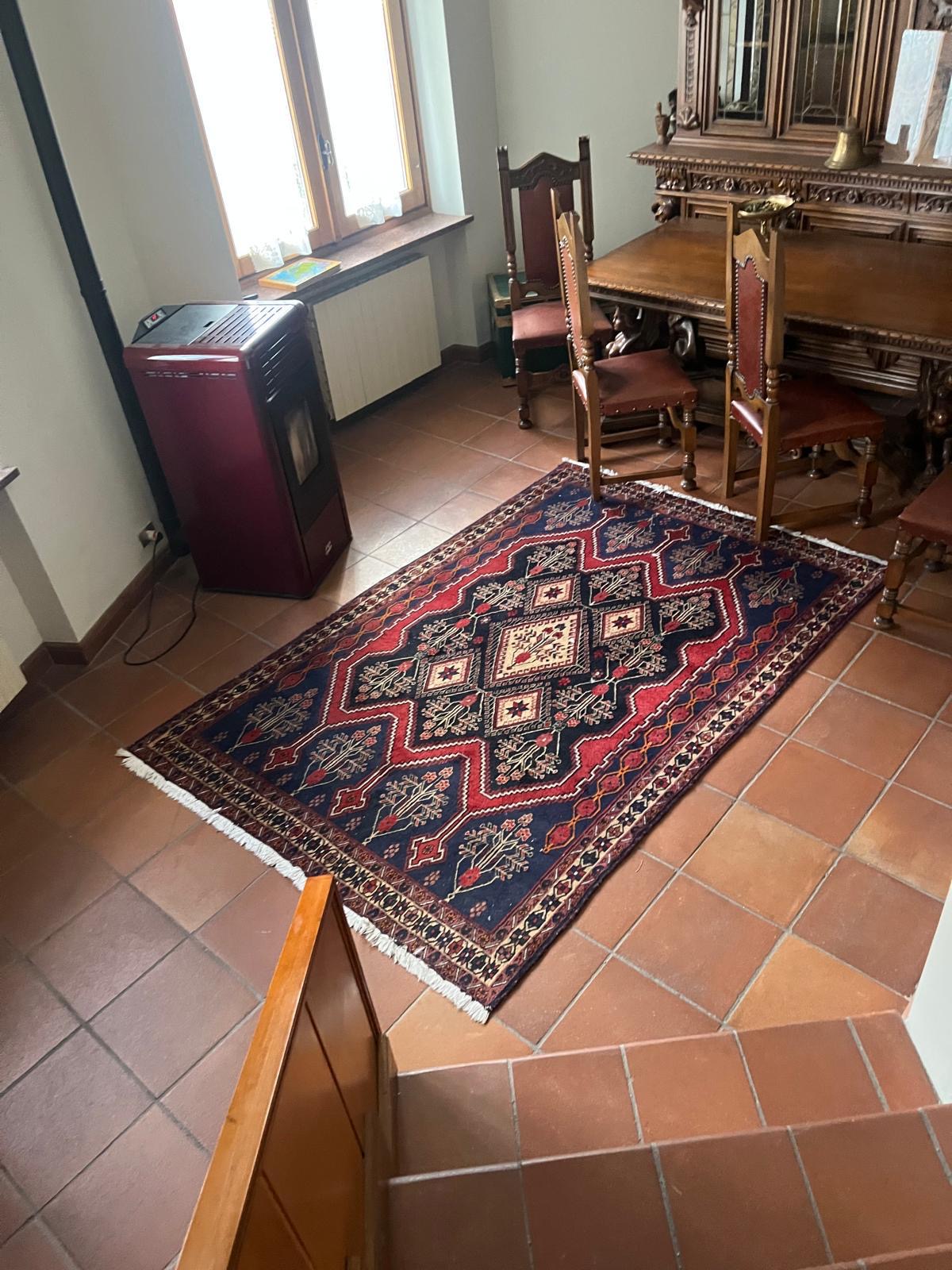 Sala da pranzo con credenza in legno intagliato e stufa a pellet