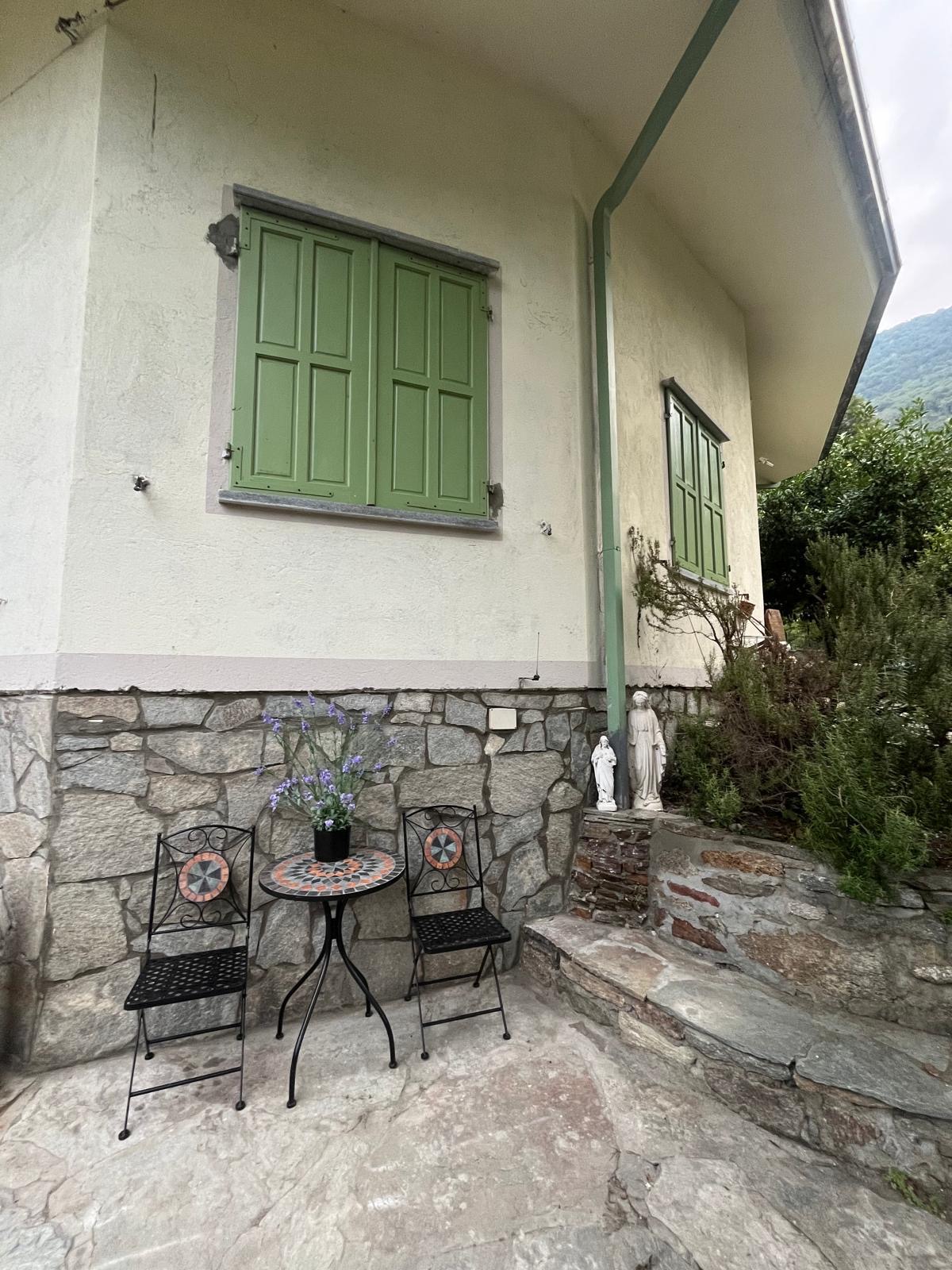 Esterno di Villa Laura con tavolino in ferro battuto e persiane verdi