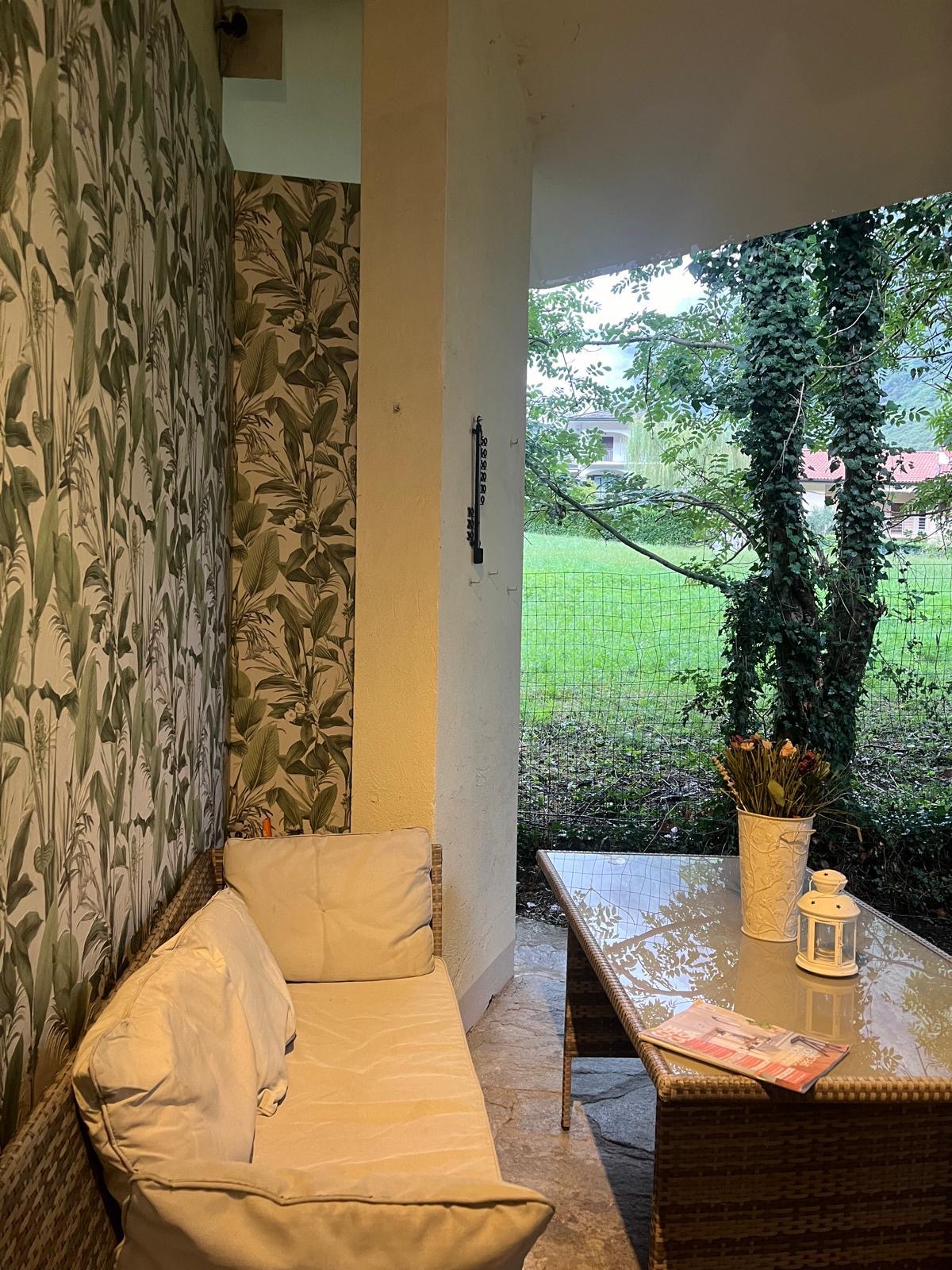 Portico coperto con divano e vista sul prato e sulle montagne