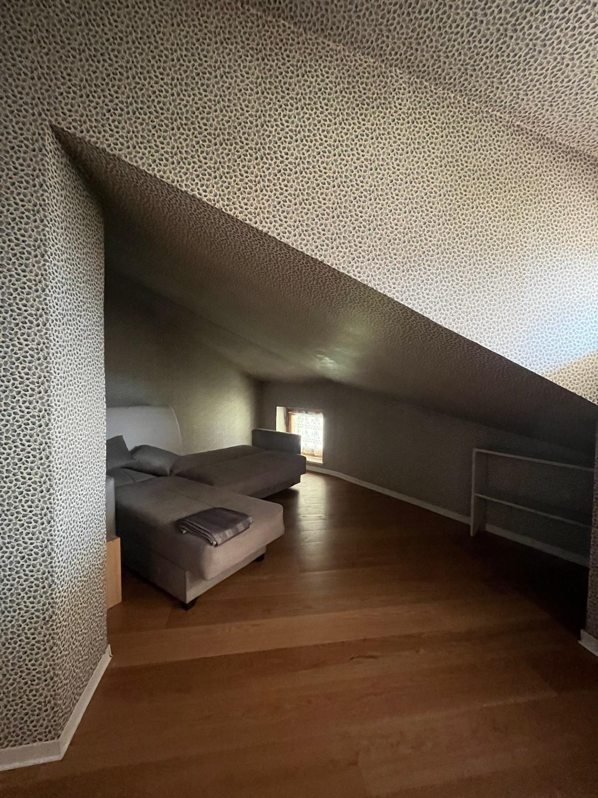 Mansarda con divano letto, parquet e finestrella sulla valle